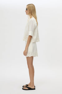 Side view CAMILLA AND MARC Chara Embroidered Cropped Shirt in Cream with short sleeves, lace hem and slight A‑line fit.