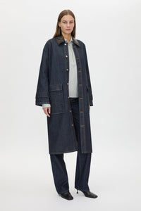 Three-quarter view CAMILLA AND MARC Enzo Denim Coat in Indigo Blue with a contrast leather collar and dual‑entry patch pockets.