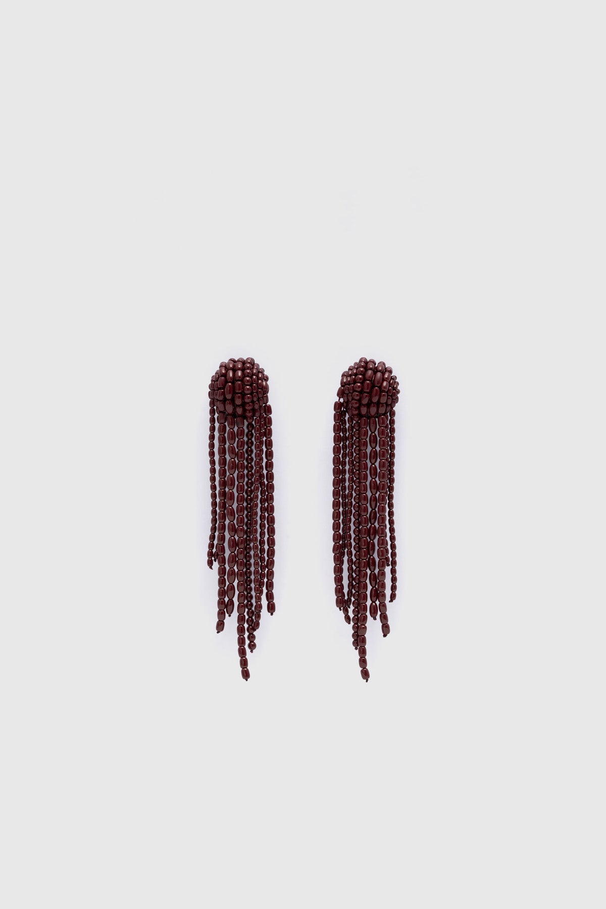 Ghost view CAMILLA AND MARC Irida Drop Earrings in burgundy with glossy beaded drop design.