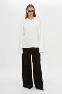 Styled view CAMILLA AND MARC Peretti long sleeve tee in white with wide shaped sleeves and ribbed neckline.
