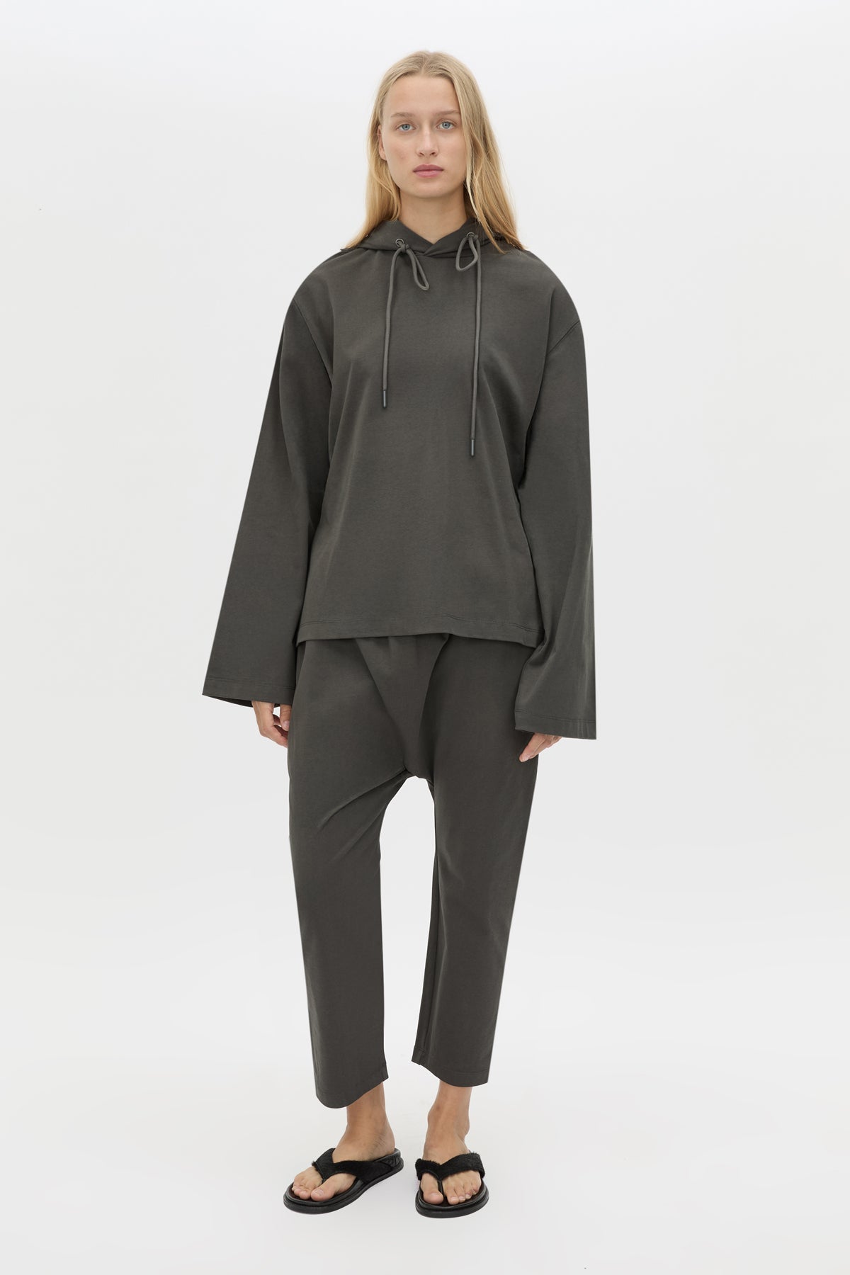 Front styled view CAMILLA AND MARC Studio Hoodie in Coal with relaxed long‑sleeve design and hooded silhouette.  