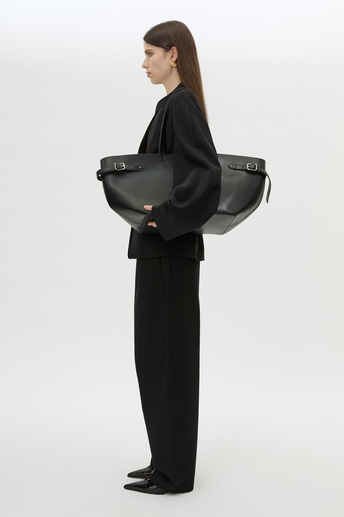 Styled view CAMILLA AND MARC Willa Tote in Black with side strap and buckle detailing and magnetic button closure.