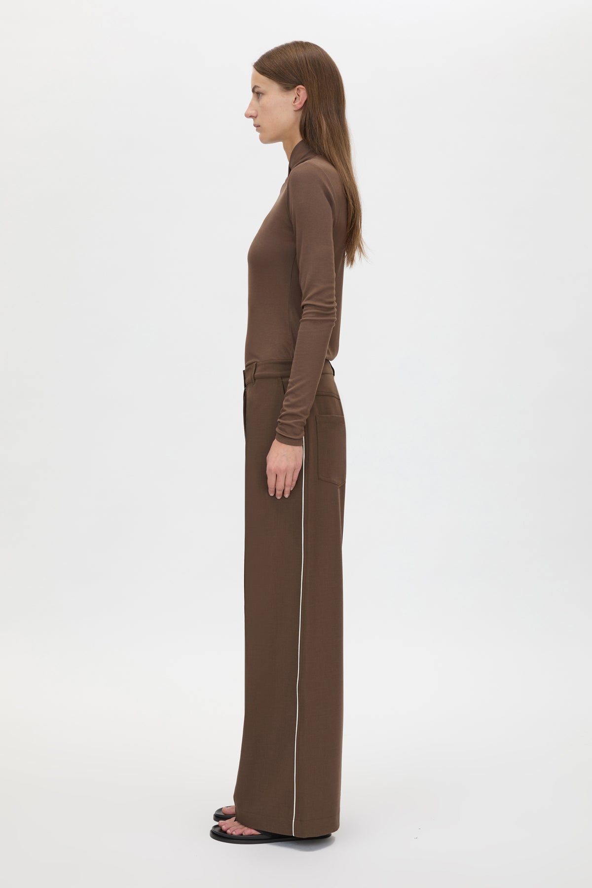 Side view CAMILLA AND MARC Axial Top in Chocolate with layered cross‑over high neck.